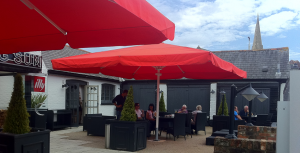 Two big red commercial umbrellas with red canopies